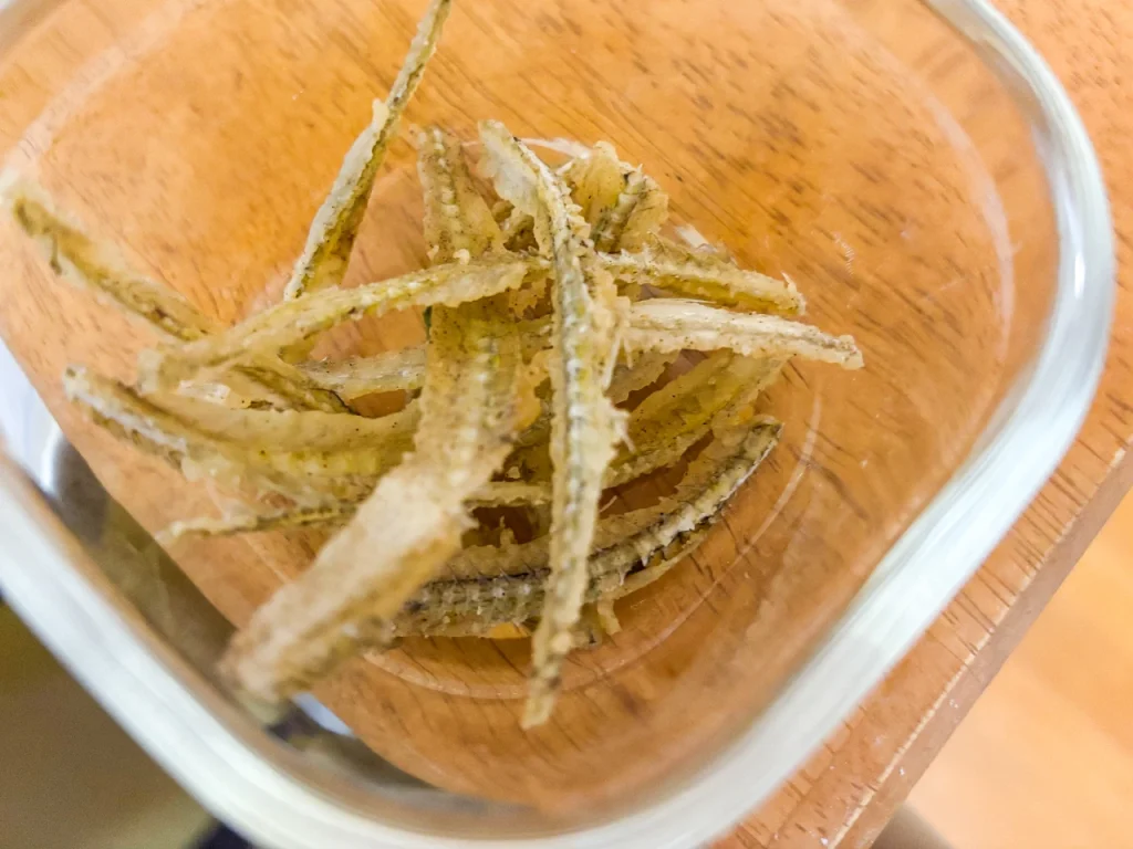 キスの中骨を揚げた骨せんべいがガラス容器に入っています。サクサクとした食感です。