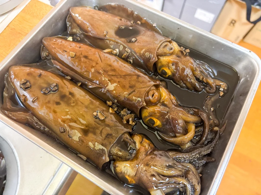 沖漬けにされたアオリイカがバットの上に並んでいます
